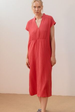 Mujer vistiendo vestido midi de color fresa con escote en pico y cuello mao