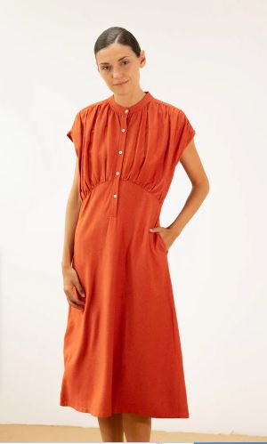 Mujer vistiendo vestido midi de color caldera, cuello mao, botones y bolsillos