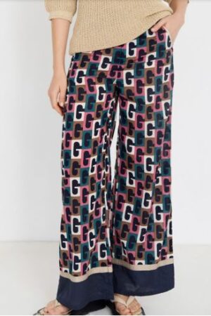 Mujer vistiendo pantalón ancho de algodón con estampado retro geométrico en azul y rosa.