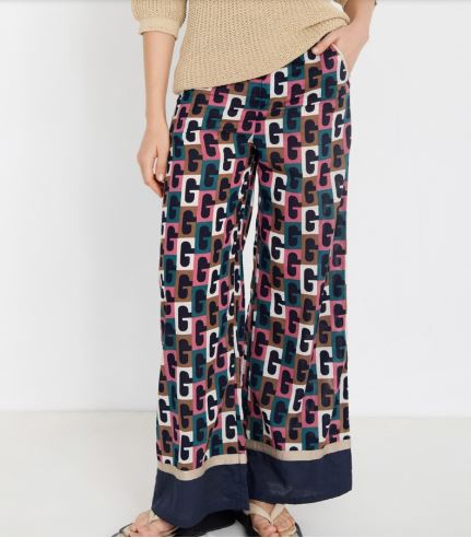 Mujer vistiendo pantalón ancho de algodón con estampado retro geométrico en azul y rosa.